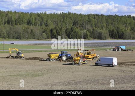 SALO, FINNLAND, 26. MAI 2017: Blick auf eine Baustelle für die Installation eines modernen landwirtschaftlichen Entwässerungssystems auf einem Feld mit Ausrüstung und Handwerkern in Aktion Stockfoto