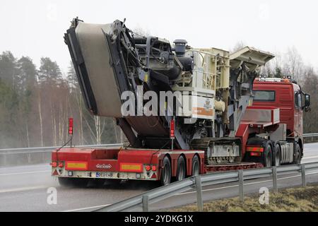 Forssa, Finnland, 23. März 2019: Der Auflieger des Typs Red Volvo FH 520 von Konekuormaus Seppanen Oy transportiert das Impaktorwerk Metso Lokotrack LT1110 entlang der Autobahn, Stockfoto