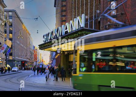 Stockmann Helsinki Centre, kulturell bedeutendes Kaufhaus in Helsinki, Finnland, mit Shopper und Straßenbahn, defokussiert. Dezember 2019, Europa Stockfoto