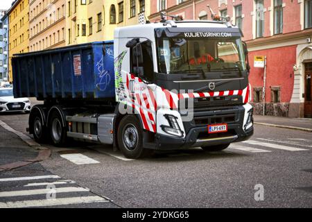 Der neue Volvo FMX500 6x2 Hakenlift Kuljetusrinki Oy auf der Stadtstraße mit Überrollbehälter auf der Rückseite des Fahrzeugs. Helsinki, Finnland. August 2021 Stockfoto