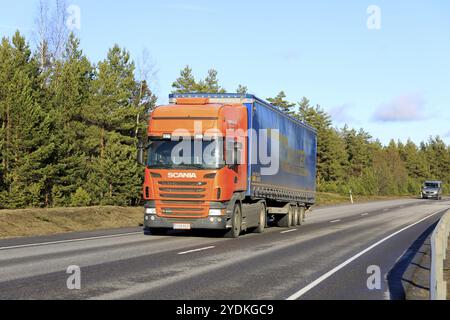 Orange Scania Truck von Tarmekal Oy zieht im Frühjahr LKW Walter Trailer in Richtung Hafen von Hanko entlang der Autobahn 25. Hanko, Finnland. Februar 2020 Stockfoto