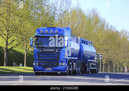 SALO, FINNLAND, 26. MAI 2017: Der in Metallic-Blau gehaltene Scania R580-Tankwagen bewegt sich auf der Straße in einer städtischen Umgebung mit grünen hinterleuchteten Bäumen im Hintergrund Stockfoto