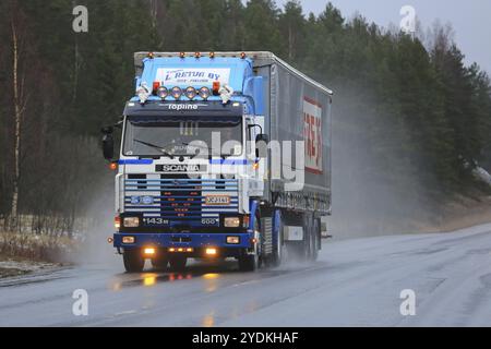 SALO, FINNLAND, 17. DEZEMBER 2016: Maßgeschneiderter Scania 143M 500 Sattelzug von L. Retva Oy und Kurvenauflieger auf nasser Straße bei Regen in Sou Stockfoto