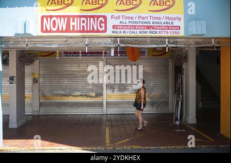 22.04.2020, Singapur, Republik Singapur, Asien, Eine Frau läuft an geschlossenen Geschäften in einer Fußgängerzone im Viertel Ang Mo Kio vorbei. Sie trägt einen Stockfoto