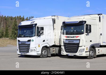 Zwei weiße schwere DAF XF-Lkw, Fahrzeug der Generation 2021 links und vorheriges Euro 6-Modell rechts geparkt am Lkw-Stopp. Salo, Finnland. April 2024 Stockfoto