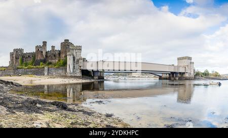 Ein HDR-Panorama mit mehreren Bildern von Conwy Castle und der Conwy Suspension Bridge, das sich bei Ebbe am 26. Oktober 2024 in Nordwales spiegelt. Stockfoto