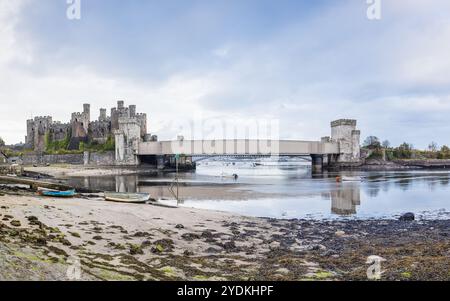 Ein HDR-Panorama mit mehreren Bildern von Conwy Castle und der Conwy Suspension Bridge, das sich bei Ebbe am 26. Oktober 2024 in Nordwales spiegelt. Stockfoto