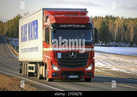 SALO, FINNLAND, 4. MÄRZ 2017: Der rote Mercedes-Benz Actros 1845 Sattelauflieger von AKO Spedition fährt in der Abenddämmerung in Südfinnland Blue Water Anhänger. Blau Stockfoto