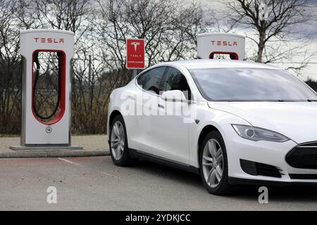 Das White Tesla Model S Elektroauto lädt an einem Frühlingstag in Paimio, Finnland, 28. April 2018, Europa an der Supercharger-Station auf Stockfoto