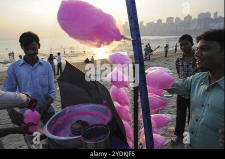 12.12.2011, Mumbai, Maharashtra, Indien, Asien, ein Straßenverkäufer verkauft am Chowpatty Beach Süßigkeiten, während die Häuser von Malabar Hill im zu sehen sind Stockfoto