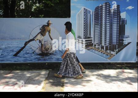 23.06.2014, Yangon, Myanmar, Asien, zwei Männer gehen an Werbetafeln vorbei, die neue Wohnungen im Zentrum der ehemaligen Hauptstadt Asiens bewerben Stockfoto