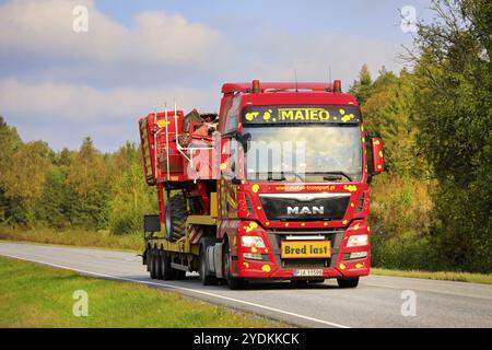 Farbenfrohe MAN TGX LKW von Mateo Transport transportiert Grimme SE 75-30 Kartoffelernter als breite Ladung an einem schönen Herbsttag. Salo, Finnland. September 25, 20 Stockfoto