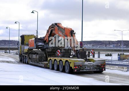 Salo, Finnland, 9. März 2019: Volvo FH16 Lkw mit Tieflader Faymonville Anhänger mit einem Hitachi ZX 350LC Raupenbagger am Wintertag, EUR Stockfoto