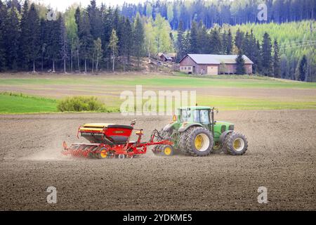 Landwirt, der an einem Frühlingstag mit dem Traktor John Deere 6820 und der Sämaschine Vaederstad Biodrill auf dem Feld arbeitet. Salo, Finnland. Mai 2021 Stockfoto