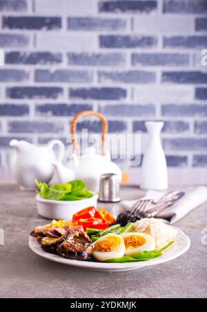 Frisches Frühstück, gekochte Eier mit Reisfleisch und Gemüse auf Teller Stockfoto