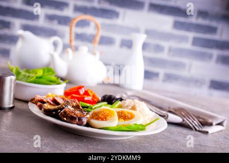 Frisches Frühstück, gekochte Eier mit Reisfleisch und Gemüse auf Teller Stockfoto