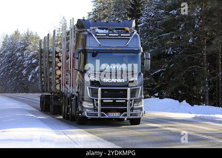 Der wunderschön gestaltete Scania R Truck Jaervi zieht Holzanhänger entlang des Highway 52 durch ländliche Winterlandschaften. Salo, Finnland. Februar 2021 Stockfoto