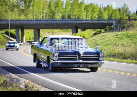 Black Pontiac Bonneville 4-türiges Hardtop, Mitte der 1960er Jahre, und Leute, die die Fahrt auf dem Salon Maisema Cruising 2019 genießen. Salo, Finnland. Mai 2019 Stockfoto