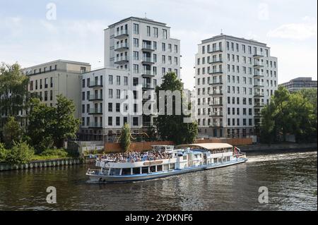 09.06.2019, Berlin, Deutschland, Europa, ein Ausflugsboot voller Touristen fährt an neuen Wohnhäusern am Spreeufer in Berlin-Moabi vorbei Stockfoto