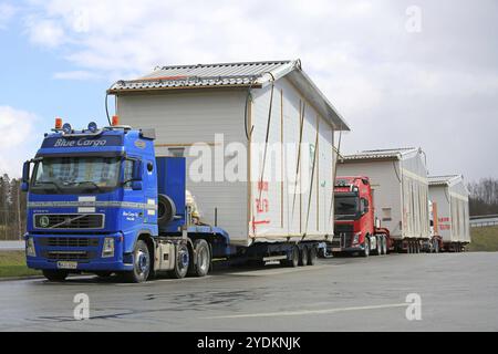 FORSSA, FINNLAND, 23. APRIL 2016: Ein Konvoi von drei Lkw, zuerst blauer Volvo FH-Auflieger, wird während eines Transports von Vorfabrika an einer LKW-Haltestelle geparkt Stockfoto