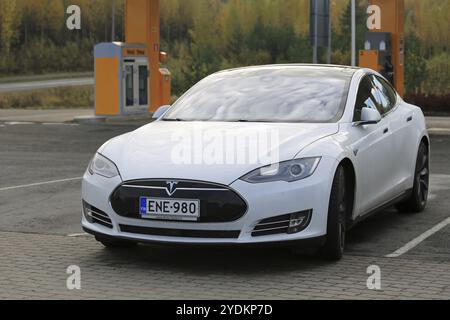 TOIJALA, FINNLAND, 17. OKTOBER 2015: Weißer Tesla Model S Elektrowagen parkt in der Nähe des Tesla Supercharger Point. Der aktuelle Stand der beiden Tesla Kompressoren Stockfoto