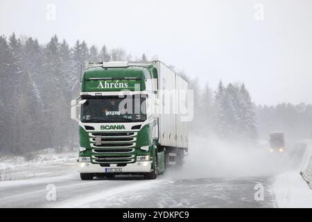 Salo, Finnland, 21. Dezember 2018: Grün-weißer Auflieger Scania R450 und ein weiterer Lkw auf verschneiten Landstraßen bei starkem Schneefall im Süden von Finl Stockfoto