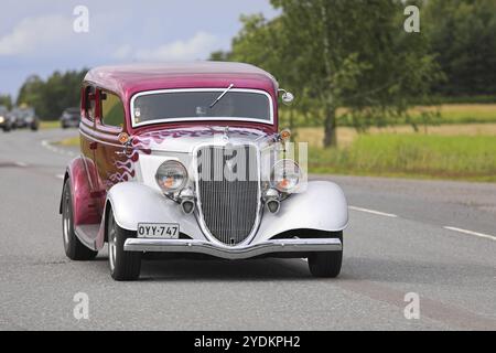SOMERO, FINNLAND, 5. AUGUST 2017: Ein klassischer Hot Rod Ford-Wagen mit magentafarbenem Flammenmuster fährt auf der Maisemaruise 2017 in Tawa entlang der Landstraße Stockfoto