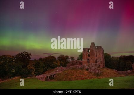 Norham Castle unter den Nordlichtern, einst der „gefährlichste Ort Englands“, liegt hoch über dem Fluss Tweed an der schottischen Grenze Stockfoto