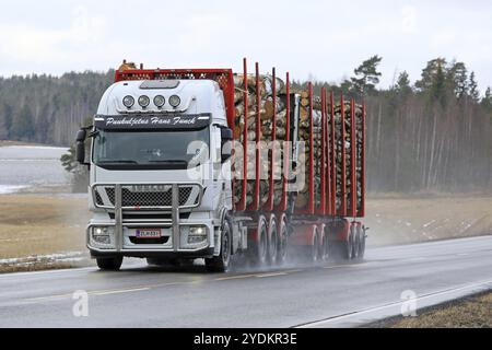 SALO, FINNLAND, 4. MÄRZ 2017: Der weiße Iveco Stralis 560 Holzfällerwagen von Puukuljetus Hans Funck transportiert im Winter eine Ladung Baumstämme auf nasser Straße in so Stockfoto