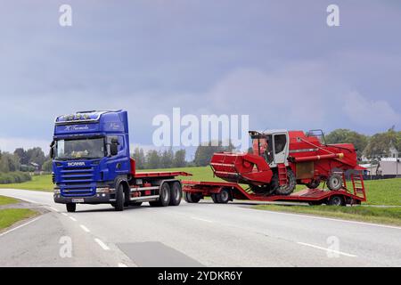 Der blaue Scania R560 Auflieger von H. Tuomola beginnt an einem Tag im frühen Herbst mit dem Transport eines roten Mähdreschers. Salo, Finnland, 2. September 2018, Eu Stockfoto