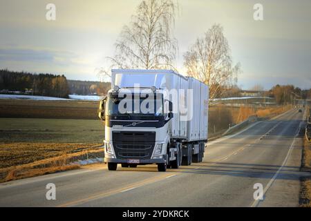 Salo, Finnland, 1. März 2019: Weißer Volvo FH-Lkw-Doppelanhänger für Posti Group, finnische Post auf der Autobahn bei Sonnenuntergang im Frühjahr, E Stockfoto