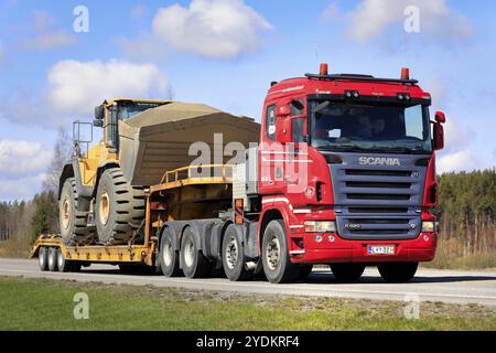 Red Scania R620 Lkw-Auflieger Veljekset Makitalo Oy transportiert den Radlader Volvo L250H auf der Autobahn als breite Last. Forssa, Finnland. April 2021 Stockfoto