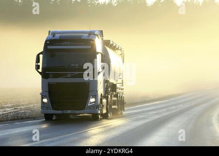 SALO, FINNLAND, 27. JANUAR 2017: Der weiße Volvo FH Sattelschlepper fährt bei Sonnenuntergang im Winter auf der Straße durch dicken, sonnendurchfluteten Nebel Stockfoto