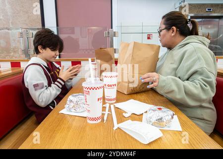 Mutter und Sohn sitzen zusammen an einem Tisch in einem fünf-Jungs-Restaurant, um zusammen zu essen. Stockfoto