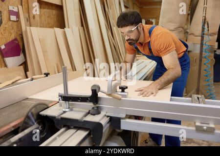 Handwerker schneidet Holz auf Stücken, die am runden Schneidtisch arbeiten Stockfoto