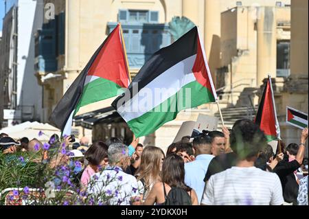 Valletta, Malta - 6. Oktober 2024: Teilnehmer einer Demonstration gegen die israelischen Aktionen im Gazastreifen mit palästinensischer Flagge Stockfoto