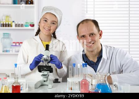 Porträt eines jungen Wissenschaftlers und eines kleinen Mädchens im Labor während eines Meisterkurses in Chemie Stockfoto