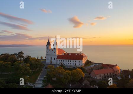 Blick auf die Skyline des berühmten Benediktinerklosters von Tihany (Tihany Abbey) mit wunderschönem farbenfrohen Himmel und Wolken bei Sonnenaufgang. Stockfoto