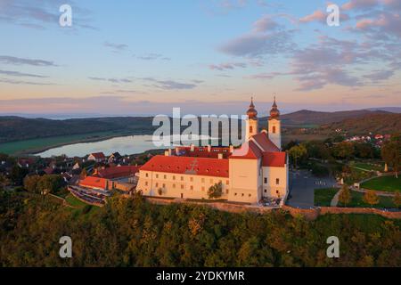 Blick auf die Skyline des berühmten Benediktinerklosters von Tihany (Tihany Abbey) mit wunderschönem farbenfrohen Himmel und Wolken bei Sonnenaufgang. Stockfoto