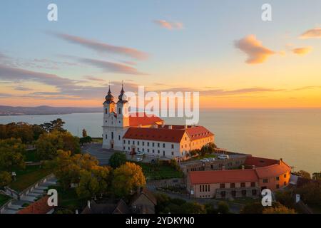 Blick auf die Skyline des berühmten Benediktinerklosters von Tihany (Tihany Abbey) mit wunderschönem farbenfrohen Himmel und Wolken bei Sonnenaufgang. Stockfoto