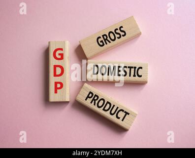 BIP – Symbol für Bruttoinlandsprodukt. Konzeptwort GDP auf Holzblöcken. Schöner rosafarbener Hintergrund. Business und BIP-Konzept. Kopierbereich. Stockfoto