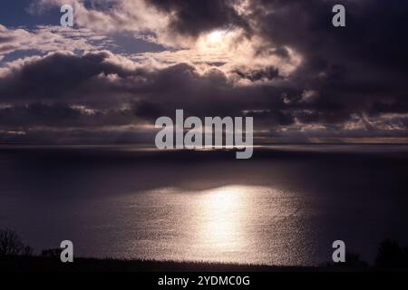 Dunkle Wolken, die am frühen Morgen vom Land über das Meer Rollen Stockfoto