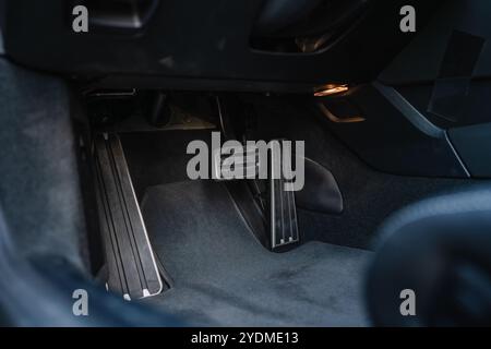 Fahrerfußbereich mit gut sichtbaren Pedalen in einem Luxusfahrzeug. Stockfoto