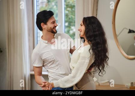 Ein Paar genießt einen fröhlichen Moment zusammen in einer gemütlichen Innenumgebung Stockfoto