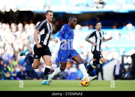 Chelsea's Nicolas Jackson (Mitte) und Newcastle United's Dan Burn (links) kämpfen um den Ball während des Premier League-Spiels in Stamford Bridge, London. Bilddatum: Sonntag, 27. Oktober 2024. Stockfoto