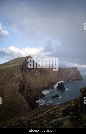 Vertikale dramatische Landschaft mit dicken Wolken, Meeresklippen und Regenbogenbögen über Madeira, Portugal Stockfoto