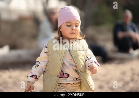Ein charmantes und verspieltes Kind genießt herrliche Momente im Freien, gekleidet in einem gemütlichen und niedlichen Outfit Stockfoto