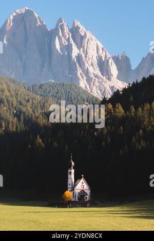 Die ikonische Kirche San Giovanni liegt im malerischen Val di Funes, eingerahmt von dichten Wäldern und den dramatischen Gipfeln der Dolomiten in Südtyro Stockfoto