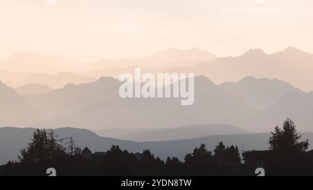 Schneebedeckte, mehrschichtige Silhouetten der Dolomiten bei Sonnenaufgang schaffen eine ruhige und beschauliche Berglandschaft im Trentino-Südtirol, Italien. Stockfoto