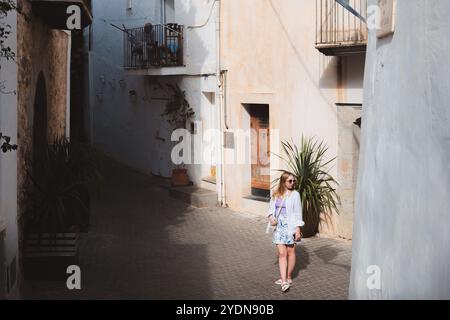 Ibiza, Spanien - 8. Oktober 2023: Entspannte Straßenszene in Ibiza-Stadt, die einen entspannten Moment der Erkundung in einer bezaubernden mediterranen Gasse festmacht. Stockfoto